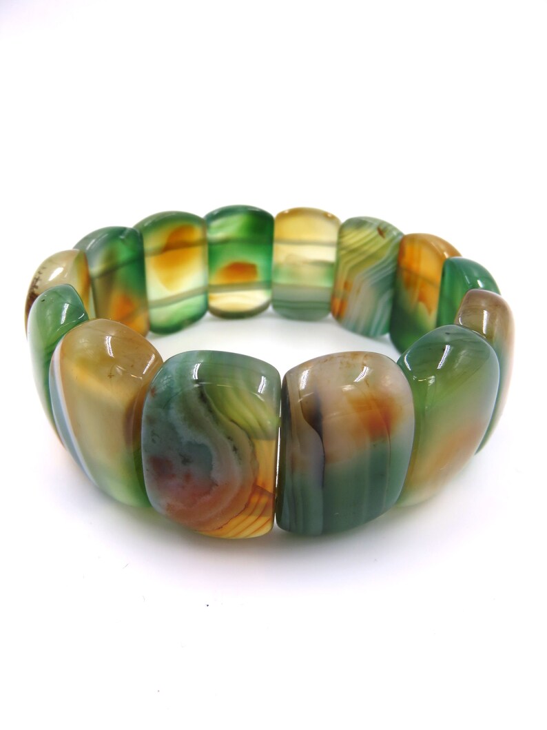 May include: A green, brown, and white agate stone bracelet with a stretchy band.
