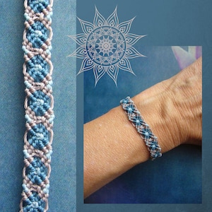 Può includere: Un braccialetto in macramè intrecciato caratterizzato da un motivo geometrico ripetitivo nei toni dell'azzurro, del blu scuro e del beige. Il design è composto da fili annodati complessi disposti in sequenza verticale, creando una fascia strutturata.