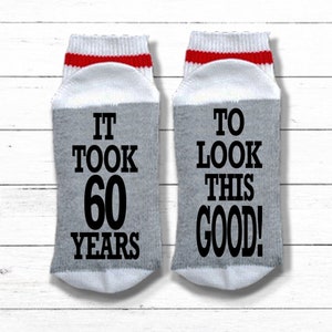 May include: A pair of gray socks with red and white stripes at the top. One sock says "It took 60 years" and the other sock says "To look this good!"