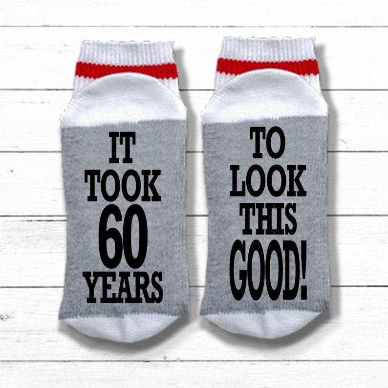 May include: A pair of gray socks with red and white stripes at the top. One sock says "It took 60 years" and the other sock says "To look this good!"