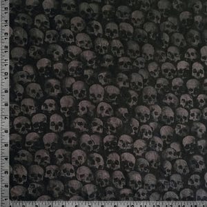 Peut inclure: Tissu noir avec un motif répété de crânes gris. Les crânes sont tous tournés vers l'avant et sont disposés de manière aléatoire.