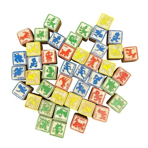 May include: A collection of vintage wooden alphabet blocks. Each block features a colourful illustration of a character and a corresponding letter. The blocks are in various colours, including red, yellow, green, and blue.