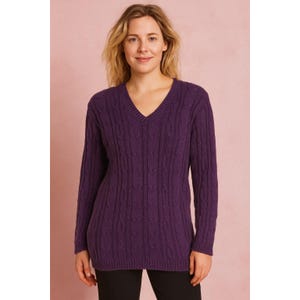 May include: A long-sleeved, deep purple cable-knit sweater with a V-neck. The sweater has a textured pattern and is made of a soft material. The model is wearing black pants. The background is a solid pink color.
