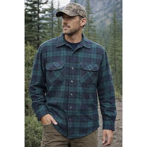 May include: A green and navy blue plaid flannel shirt with two chest pockets and button-down closure. The shirt is worn with a camouflage baseball cap and brown trousers. The shirt is a classic outdoor style.