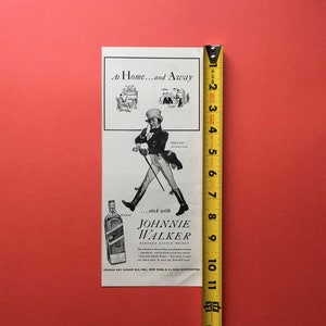 Puede incluir: Anuncio impreso en blanco y negro para Johnnie Walker Blended Scotch Whisky. El anuncio presenta a un hombre con un sombrero de copa y un bast&oacute;n, con el texto "At Home...and Away...stick with Johnnie Walker".