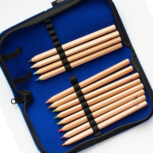 May include: A blue pencil case with a zip fastening, containing a set of 12 wooden pencils with coloured tips. The case has a label that reads "100% Wolle".