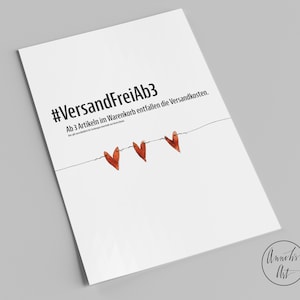 Puede incluir: Tarjeta blanca con el texto "#VersandFreiAb3 Ab 3 Artikeln im Warenkorb entfallen die Versandkosten." y tres corazones rojos colgando de una cuerda.