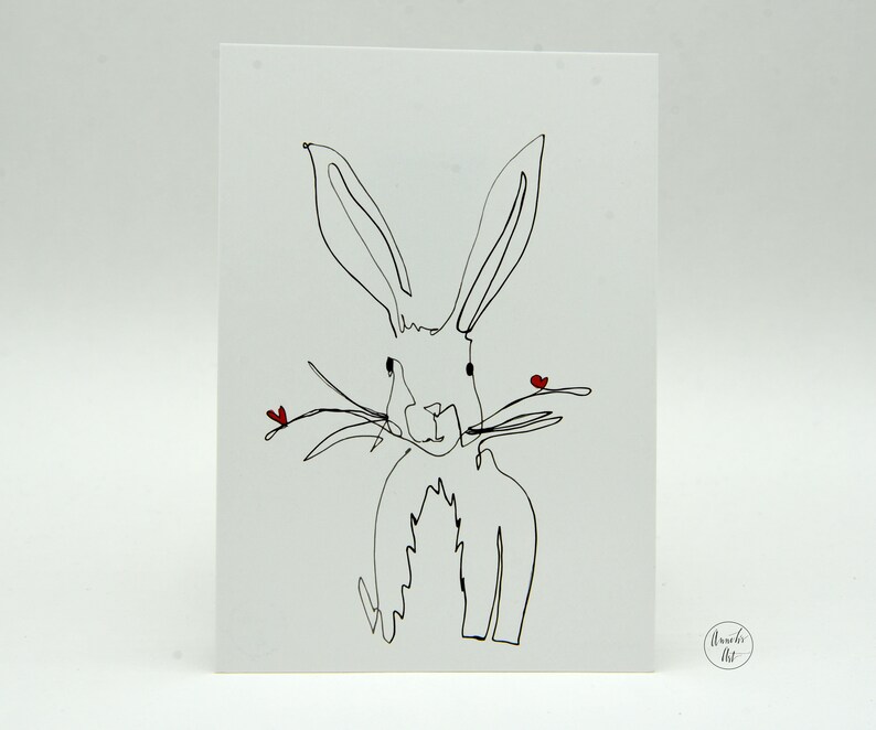 May include: A black and white line drawing of a rabbit with two small red hearts on its nose. The drawing is on a white card with the words "Amanda Art" in the bottom right corner.