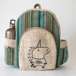May include: A beige and green striped backpack with a cartoon unicorn design on the front pocket. The backpack has a side pocket with a water bottle. The backpack is made of a woven material.