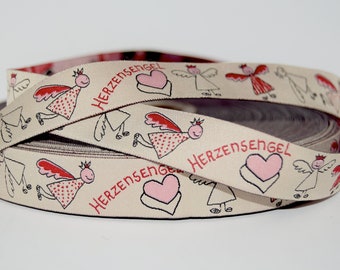 May include: Beige ribbon with a repeating pattern of red-winged angels, hearts, and the text "HERZENSENGEL".
