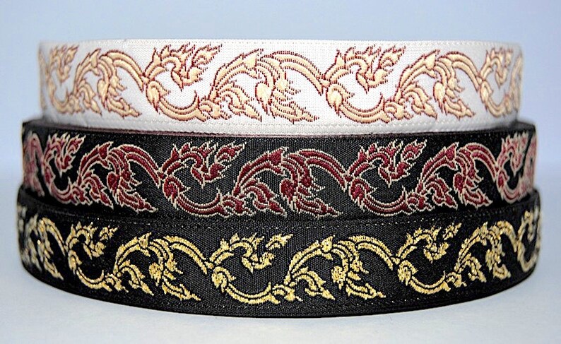 May include: Three rolls of black, white, and burgundy ribbon with a gold and white floral pattern.
