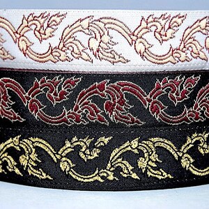 May include: Three different trims of black fabric with gold and red embroidery. The trims feature a repeating pattern of stylized floral designs.