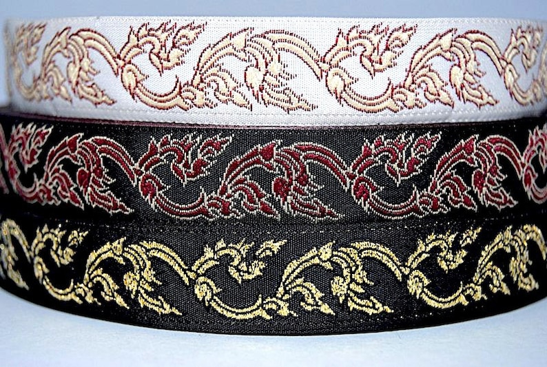 May include: Three different trims of black fabric with gold and red embroidery. The trims feature a repeating pattern of stylized floral designs.