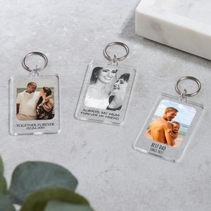 May include: Three clear acrylic keychains with photos and text. The first keychain has a photo of a couple and the text "Together Forever 02.04.2015". The second keychain has a photo of two women and the text "Always my Mum Forever my Friend". The third keychain has a photo of a father and child and the text "Best Dad Since 2022".