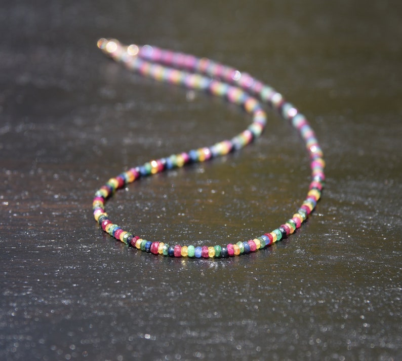 Pu&ograve; includere: Una collana di perline colorate con chiusura dorata. La collana presenta piccole perline sfaccettate multicolori, tra cui rosso, blu, giallo e verde. Le perline sono infilate insieme per creare un gioiello delicato e accattivante.