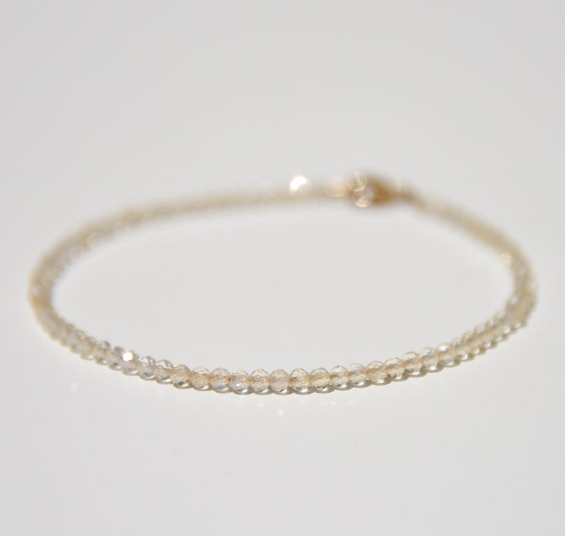 K&ouml;nnte beinhalten: Ein zartes Armband aus klaren Quarzperlen mit einem goldenen Verschluss.