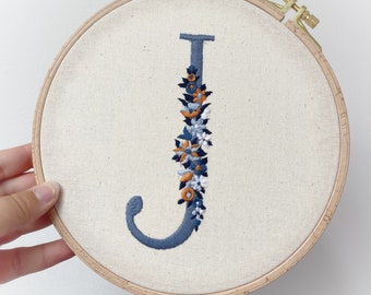 Embroidery letter in the embroidery frame smoke blue / orange