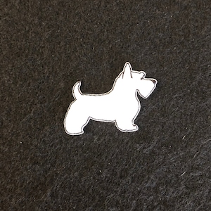 Könnte beinhalten: Weißer Filz-Applikationen eines Schottischen Terriers auf schwarzem Hintergrund.