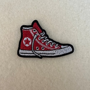 May include: Red embroidered patch of a high-top sneaker with white laces and a white star logo.