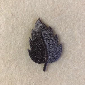 May include: A dark gray fabric leaf with a textured surface.