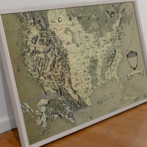 May include: A vintage-style map of the United States with a green and brown color scheme. The map is framed in a white frame and includes the text "United States of America" and "Gulf of Mexico".