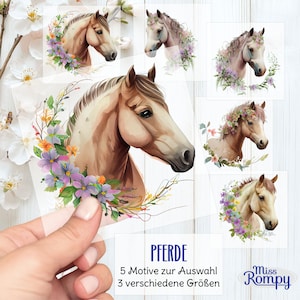 Peut inclure: Plusieurs autocollants sur le thème des chevaux avec des illustrations à l'aquarelle. Les autocollants présentent des têtes de chevaux ornées de compositions florales de différentes couleurs. Le texte "PFERDE" est visible, ainsi que du texte allemand supplémentaire.