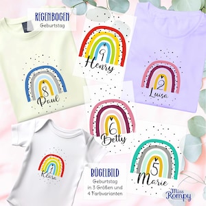 Könnte beinhalten: Eine Auswahl an hellen T-Shirts und einem weißen Babybody mit Regenbogenmotiven, Namen und Zahlen. Die Designs enthalten schwarze Punkte und den Text REGENBOGEN Geburtstag sowie BÜGELBILD Geburtstag in 3 Größen und 4 Farbvarianten.