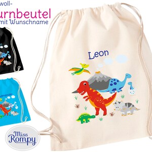 Könnte beinhalten: Eine weiße Kordeltasche mit einem Dinosaurier-Motiv. Die Tasche hat einen roten Dinosaurier, einen blauen Dinosaurier, einen grünen Dinosaurier, einen grauen Dinosaurier und einen grünen fliegenden Dinosaurier. Die Tasche hat auch einen Vulkan und Wolken. Die Tasche hat den Namen "Leon" darauf geschrieben. Die Tasche ist in verschiedenen Farben erhältlich.