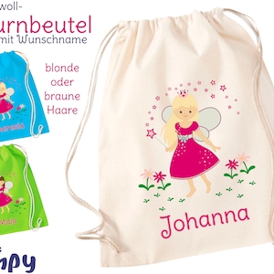 Könnte beinhalten: Ein weißer Baumwoll-Turnbeutel mit einer rosa Feen-Illustration und dem Namen Johanna auf der Vorderseite. Der Beutel hat einen blauen und grünen Kordelzug. Der Beutel ist in verschiedenen Farben erhältlich.