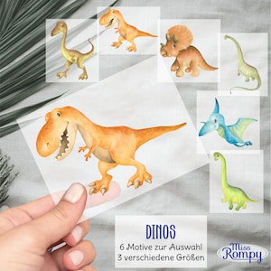 Peut inclure: Six illustrations de dinosaures à l'aquarelle sur des feuilles transparentes. Les dinosaures sont un brachiosaure vert, un ptérodactyle bleu, un tricératops jaune, un T-Rex jaune, un stégosaure vert et un dinosaure au long cou jaune. Le texte "DINOS" est en bas de l'image avec le texte "6 Motive zur Auswahl 3 verschiedene Größen" et "Miss Rompy" en dessous.