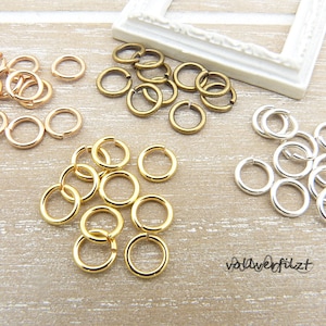 Könnte beinhalten: Sortiment an Sprungringen in Gold, Silber und Roségold. Die Sprungringe sind klein und perfekt für die Schmuckherstellung.