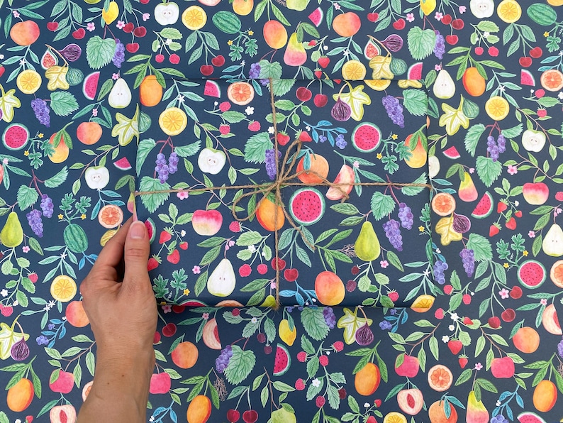 Summer fruit wrapping paper printed using vegetable inks. Fruits including, watermelon, lemons, oranges, pears, apples, grapes, mangoes, figs, peach, cherries. strawberries, raspberries, blackberries and blueberries. Originally painted with watercolours. Printed on a dark teal background.