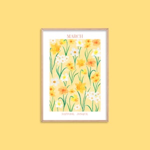 May include: A framed print with a yellow background featuring a pattern of white and yellow daffodils and jonquils. The text "MARCH" is at the top of the print and "DAFFODIL JONQUIL" is at the bottom.