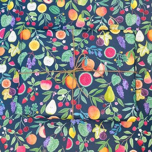 Summer fruit wrapping paper printed using vegetable inks. Fruits including, watermelon, lemons, oranges, pears, apples, grapes, mangoes, figs, peach, cherries. strawberries, raspberries, blackberries and blueberries. Originally painted with watercolours. Printed on a dark teal background.