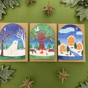 3 Christmas cards with a domed shape at the top. Season’s greetings, Merry Christmas and Merry and Bright. Winter scene snowglobe watercolour illustrations.