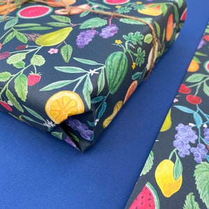 Summer fruit wrapping paper printed using vegetable inks. Fruits including, watermelon, lemons, oranges, pears, apples, grapes, mangoes, figs, peach, cherries. strawberries, raspberries, blackberries and blueberries. Originally painted with watercolours. Printed on a dark teal background.