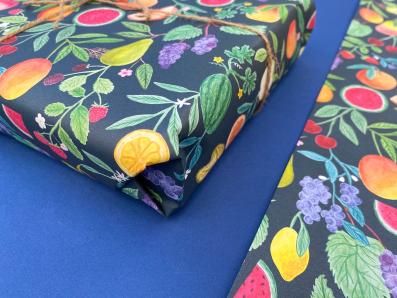 Summer fruit wrapping paper printed using vegetable inks. Fruits including, watermelon, lemons, oranges, pears, apples, grapes, mangoes, figs, peach, cherries. strawberries, raspberries, blackberries and blueberries. Originally painted with watercolours. Printed on a dark teal background.