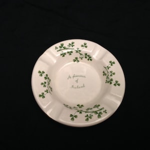 May include: White ceramic ashtray with a green shamrock design and the text "A souvenir of Ireland".