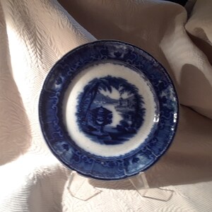 May include: A blue and white porcelain plate with a blue and white floral design. The plate has a scalloped edge and a raised rim.
