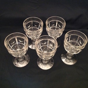 May include: Set of five clear glass wine goblets with a geometric pattern.