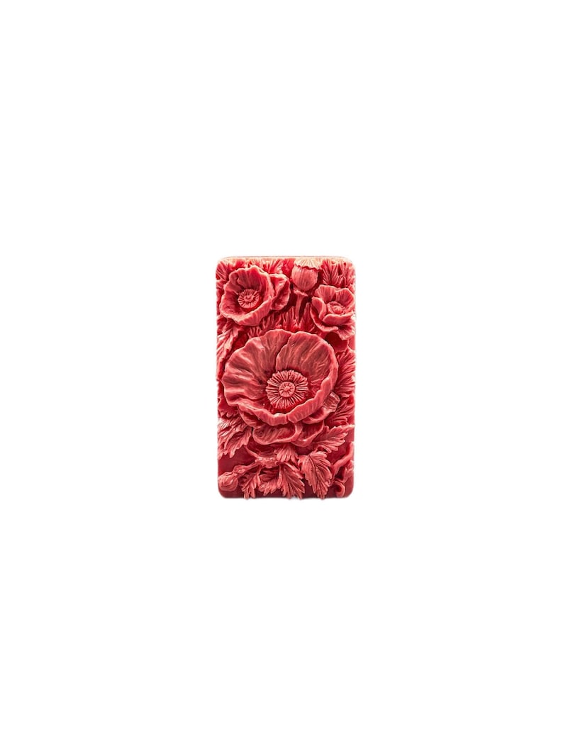 May include: A rectangular bar of soap with a detailed floral design. The soap is a deep pink color and features a cluster of poppy flowers.
