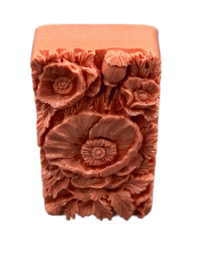 May include: A rectangular bar of soap with a floral design. The soap is a light peach color and features a raised design of poppies and leaves.