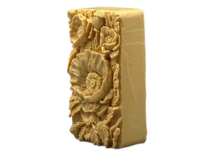 May include: A rectangular bar of soap with a detailed floral design. The soap is beige and features a raised design of poppies and leaves.