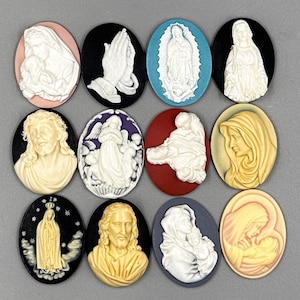 Puede incluir: Doce colgantes de camafeo ovalados con im&aacute;genes religiosas. Los camafeos est&aacute;n hechos de resina blanca y presentan varias figuras, incluyendo Jes&uacute;s, Mar&iacute;a y &aacute;ngeles. Los colgantes est&aacute;n engastados en fondos de diferentes colores, incluyendo negro, azul, rojo y morado.