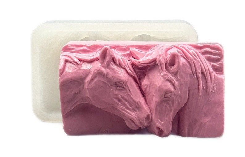K&ouml;nnte beinhalten: Eine rosa Silikonform zum Herstellen von Seife oder Kunstharz. Die Form zeigt zwei Pferdek&ouml;pfe, die sich gegen&uuml;berstehen und sich mit der Nase ber&uuml;hren.