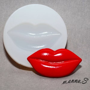 Peut inclure: Un moule en silicone rouge pour faire une paire de lèvres. Le moule est présenté à côté d'une coulée de résine rouge brillante et finie des lèvres.
