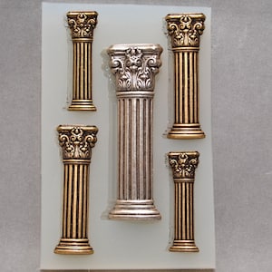 May include: Five decorative silicone molds for baking, each shaped like a different column with ornate details. The molds are on a white background.