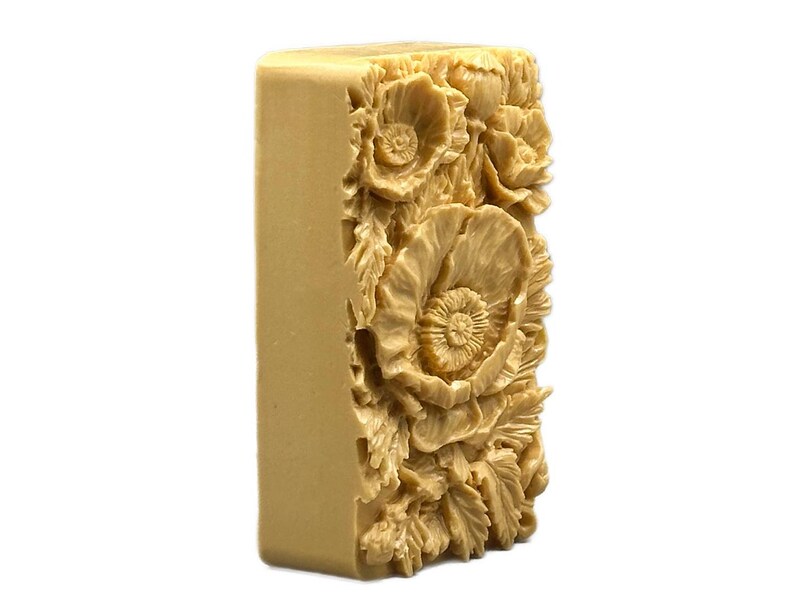 May include: A rectangular bar of soap with a detailed floral design. The soap is a light beige color and features a raised design of poppies and leaves.