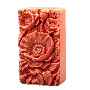 May include: A rectangular bar of soap with a detailed floral design. The soap is a light coral color and features a raised design of poppies and leaves.