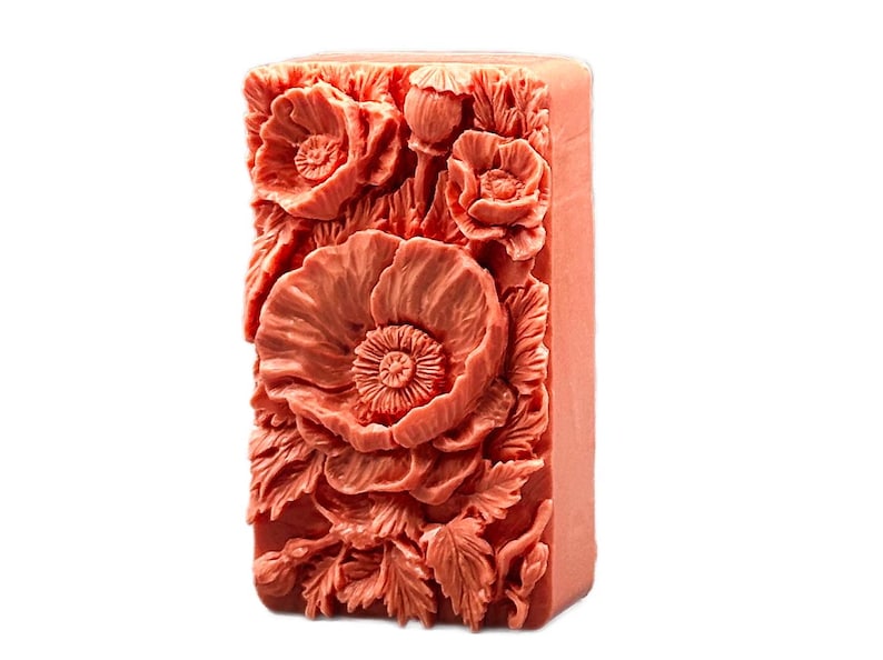 May include: A rectangular bar of soap with a detailed floral design. The soap is a light coral color and features a raised design of poppies and leaves.